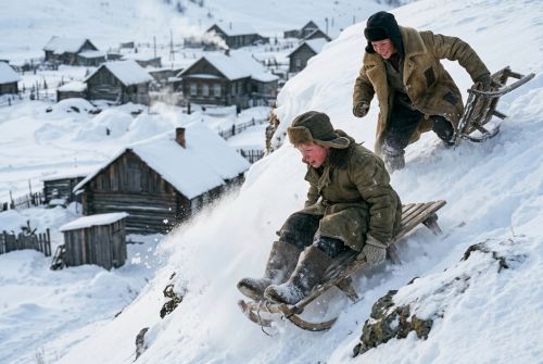 Витя и Санька катаются на санках с высокого снежного обрыва.